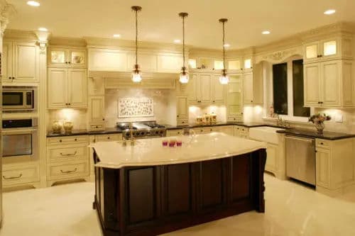 Stylish modern kitchen with cream cabinets, elegant island, and pendant lighting.