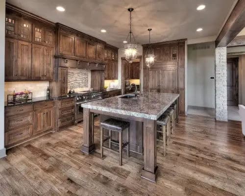Spacious modern kitchen with wooden cabinetry, granite island, and elegant lighting.